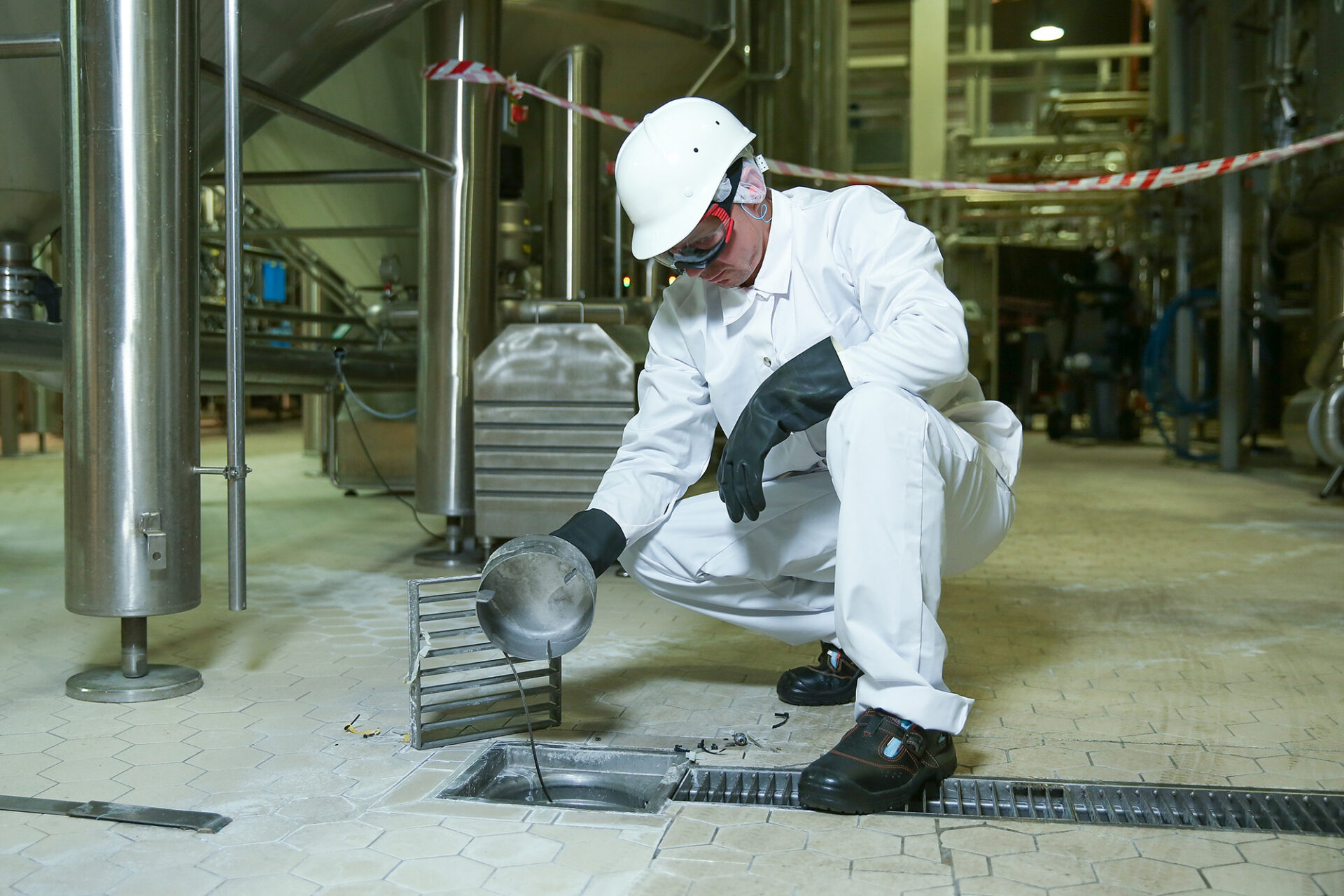 man inspecting facility drain